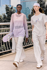 a lady wears a purple mesh hoodie with white pants